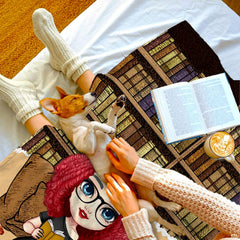 Stylized couch setting featuring curly reader girl throw blanket draped across living room furniture.