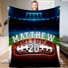 Football field night stadium lights throw blanket displaying a textured football on the field under arena lights