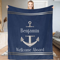 Person holding up the deep navy blue textile displaying a silver ship anchor.
