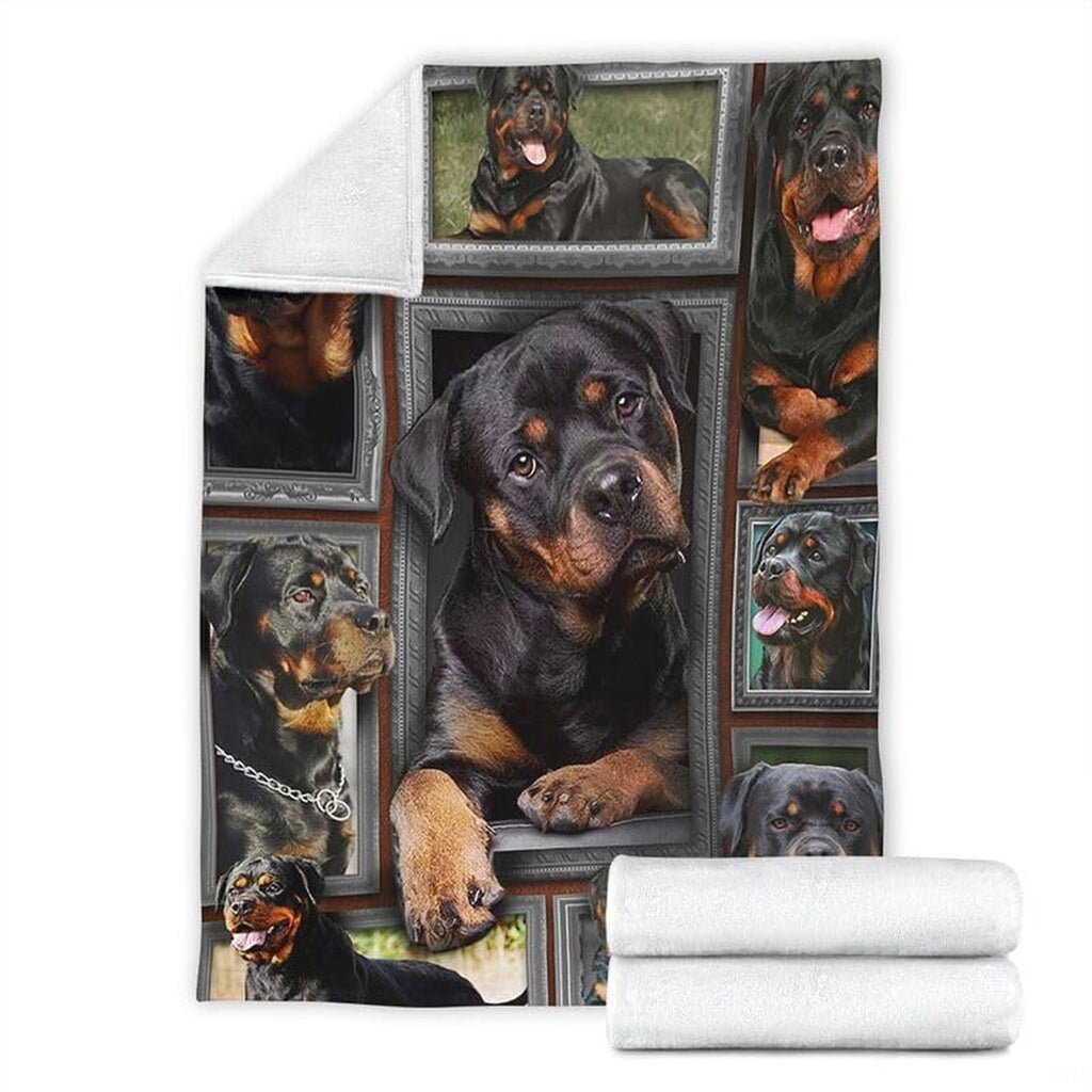 Folded corner and rolled layout of the Rottweiler blanket showing the white reverse side.