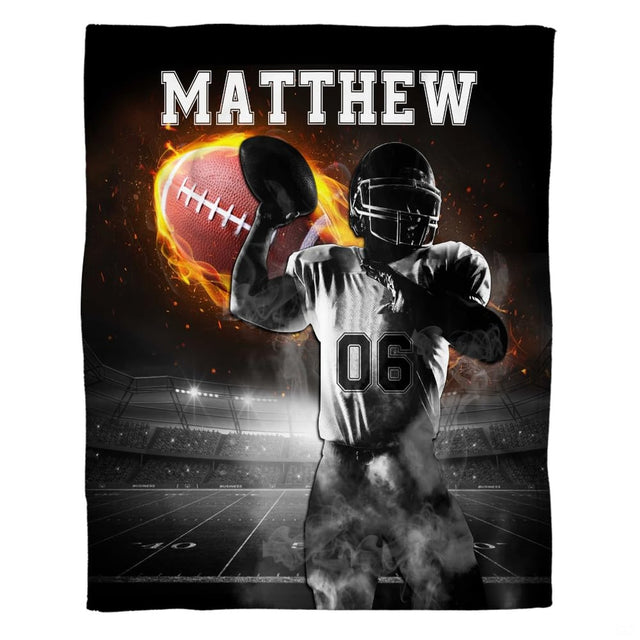 American football quarterback preparing to throw flaming football under stadium lights, view 2.