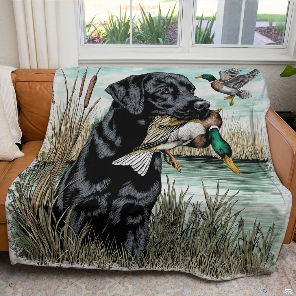 Overhead presentation of black lab duck hunting bedding showing retriever, lakeside cattails, and calm mint water hues.