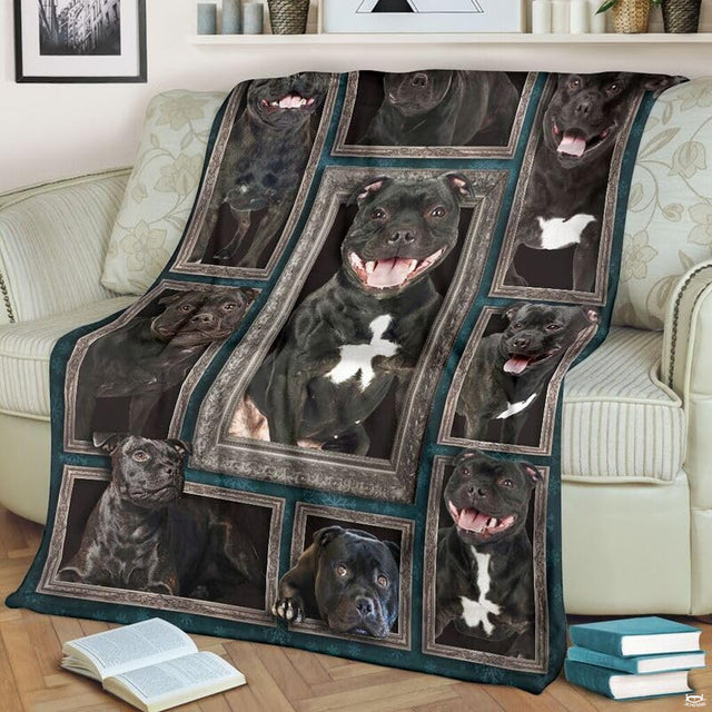 Staffordshire Bull Terrier throw blanket styled across a living room sofa near stacked books and a cup.