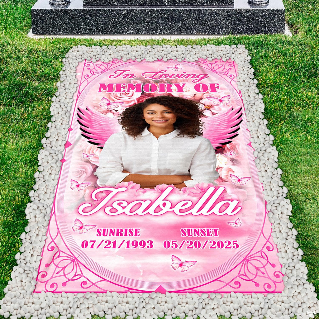 Cemetery perspective showing rose and angel wing tribute before dark granite headstone.