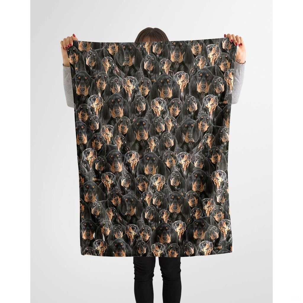 Black and Tan Coonhound collage blanket styled across a sofa in a bright living room.