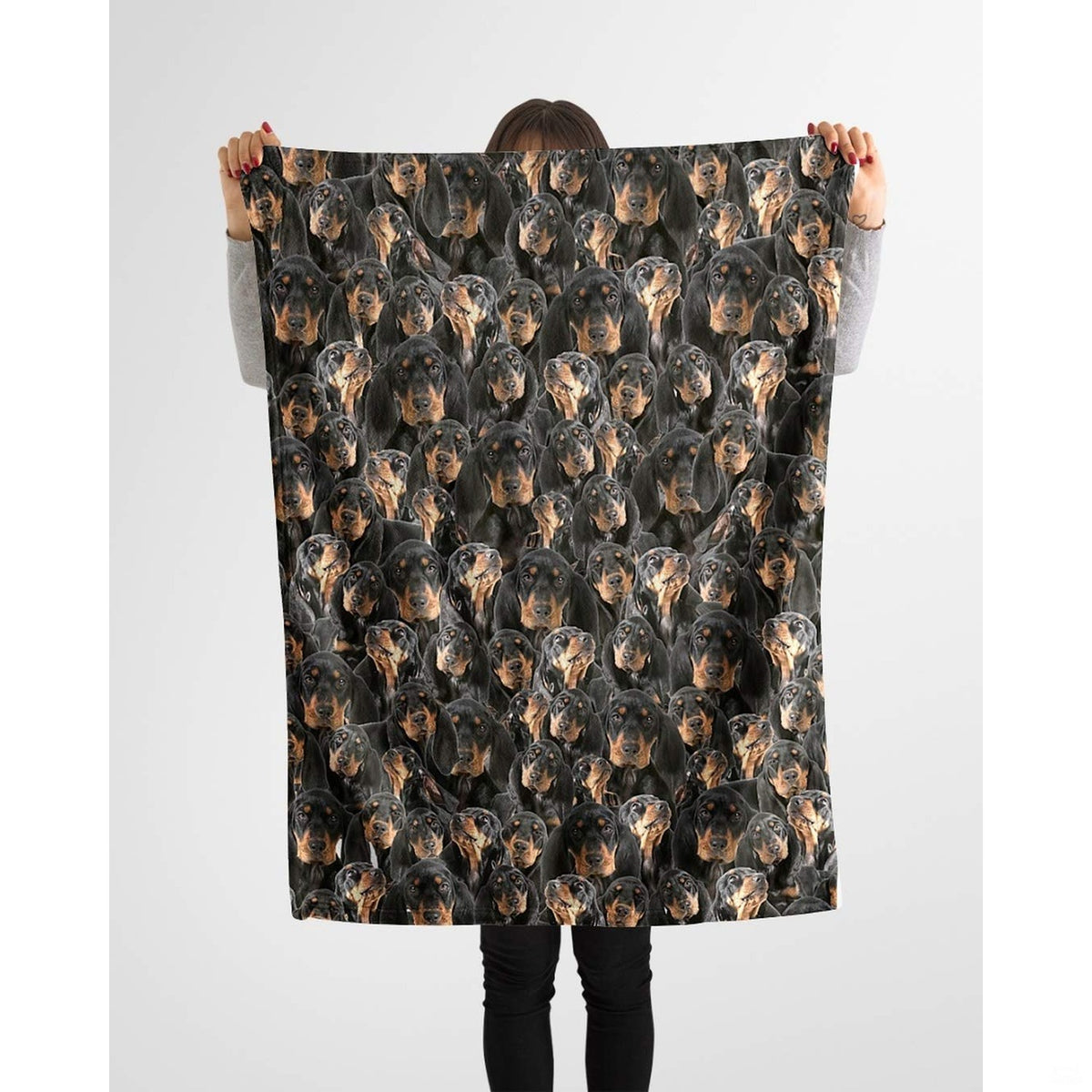 Black and Tan Coonhound collage blanket styled across a sofa in a bright living room.