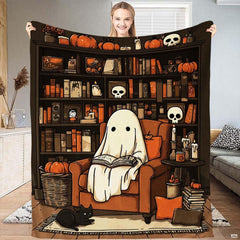 Close up view of illustrated ghost sitting in an armchair reading a book on Halloween bedding print.