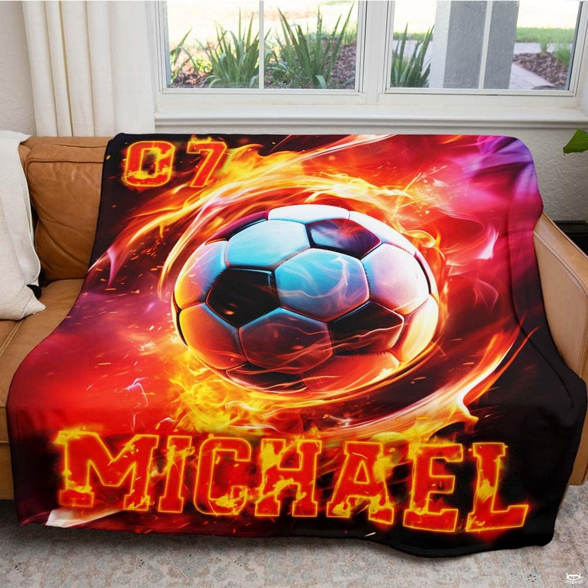 Living room display with the fiery soccer vortex design draped over a couch beside a window.
