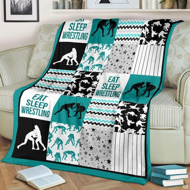 Teal wrestling patchwork blanket draped over a living room couch beside a stack of books.