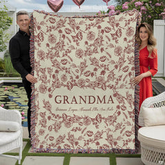 Burgundy floral toile pattern with central wreath and woven fringe edge on Blanket.