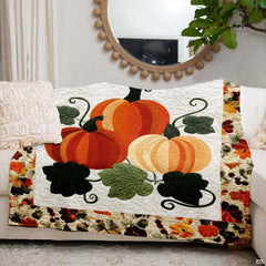 Autumn pumpkin trio blanket styled across a living room armchair beside festive seasonal home decor