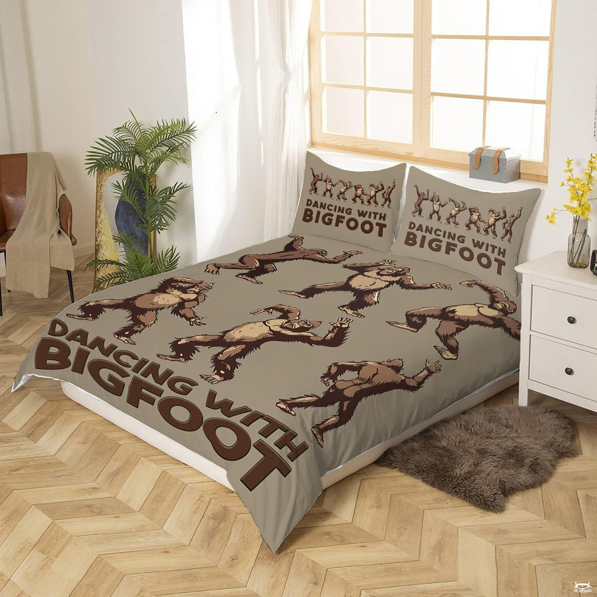 Close-up view of Bigfoot bedding showcasing humorous dancing creature artwork and taupe tones