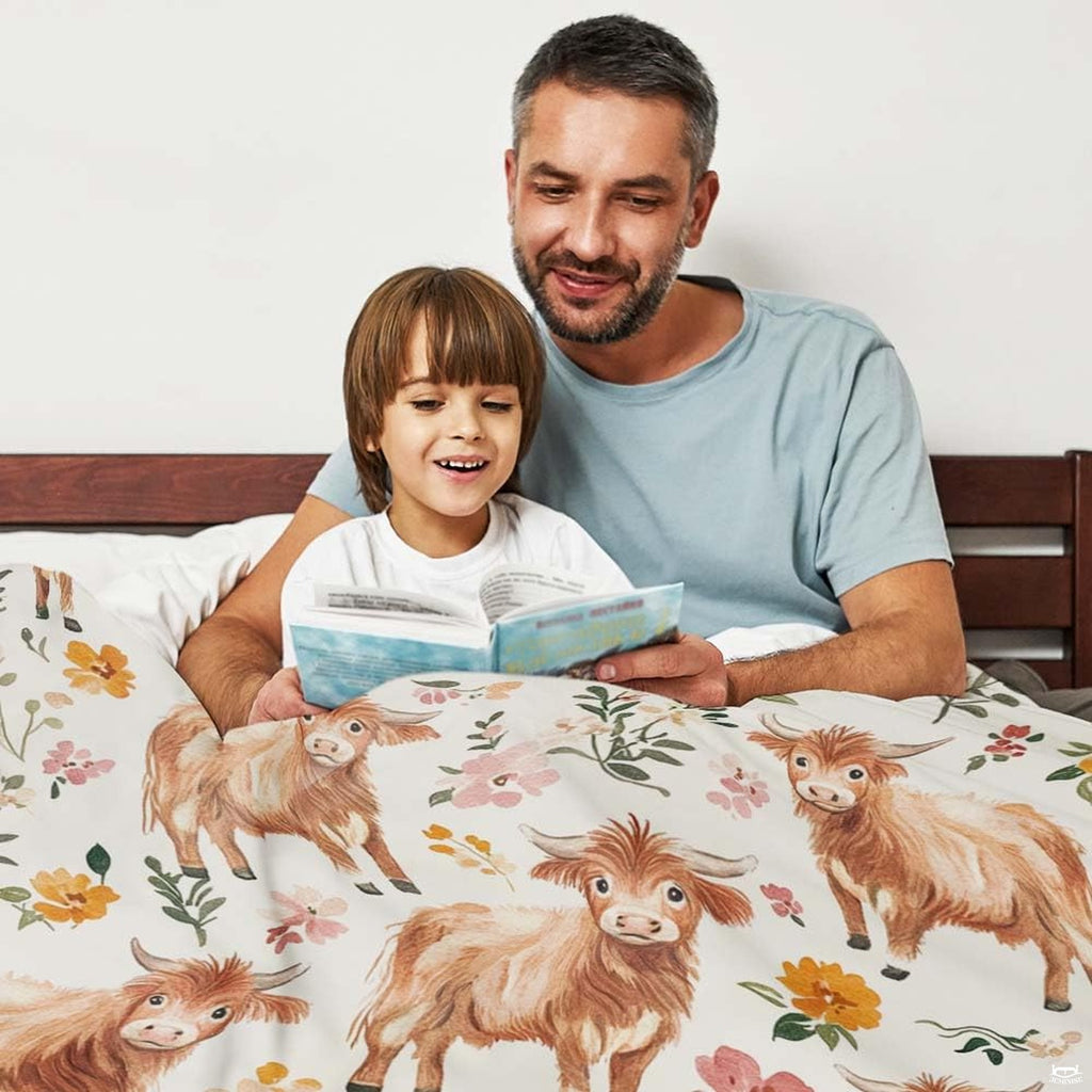Overhead view of repeating highland cow and botanical blossom pattern across bedding set.
