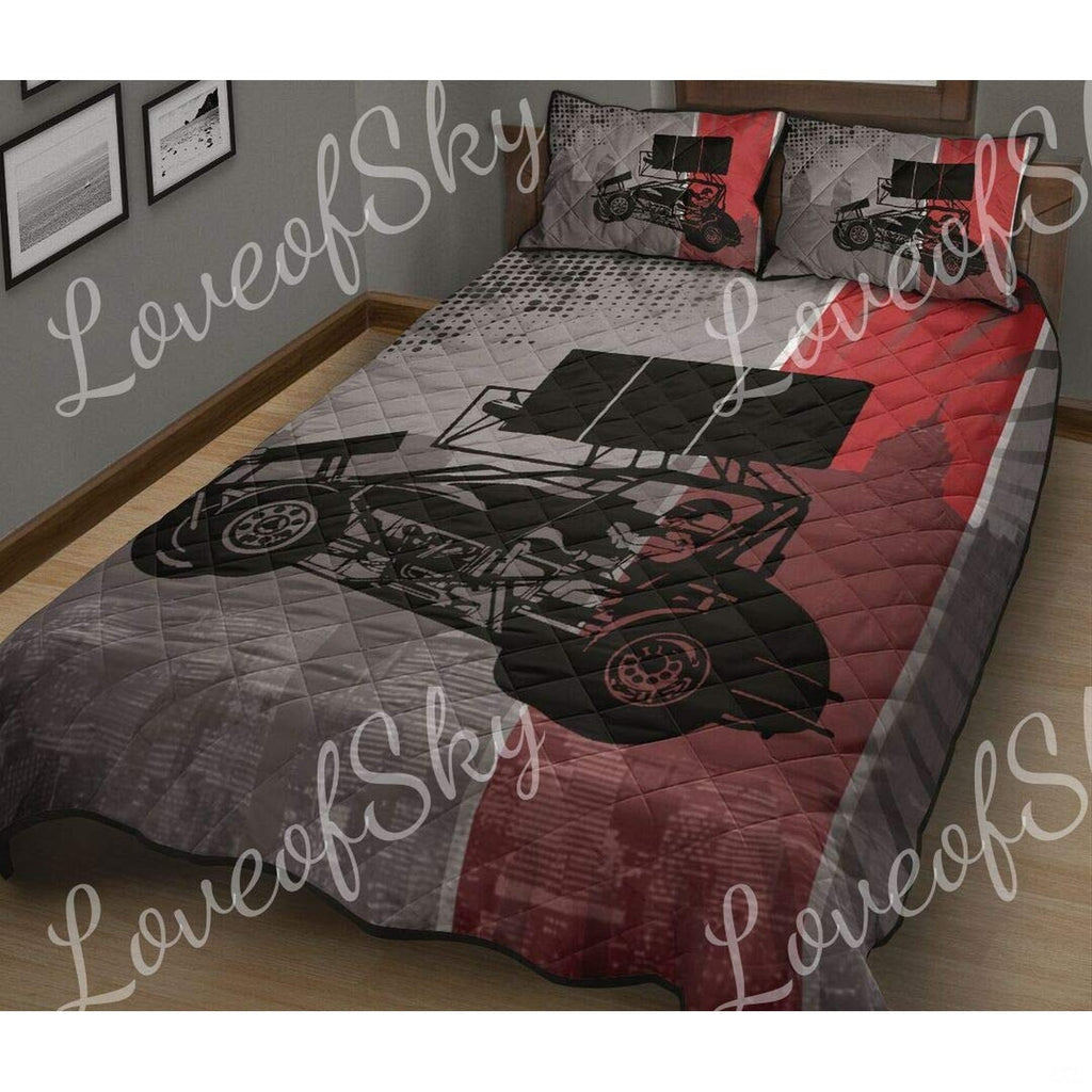 Close-up perspective of racing bedding highlighting red and grey sprint car artwork and textured track smoke