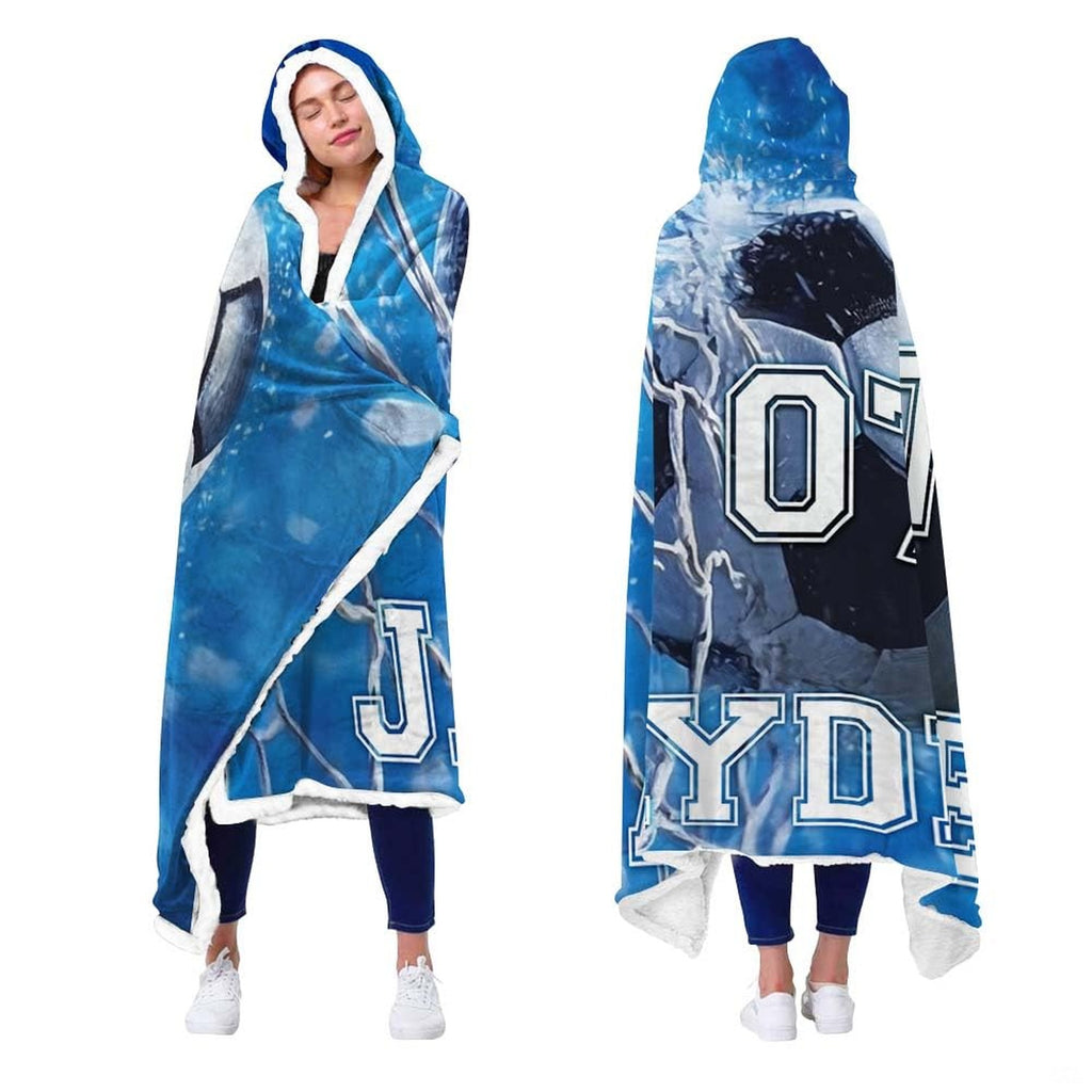 Person showcasing soccer sports blanket with goal net impact artwork and blue bokeh lights