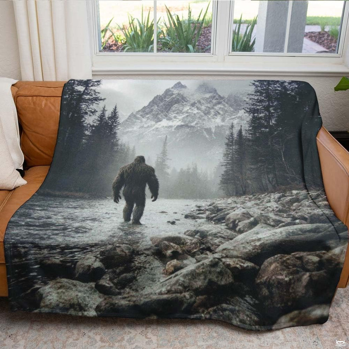 Bigfoot walking through a rocky mountain river toward snow-capped peaks, view 5.