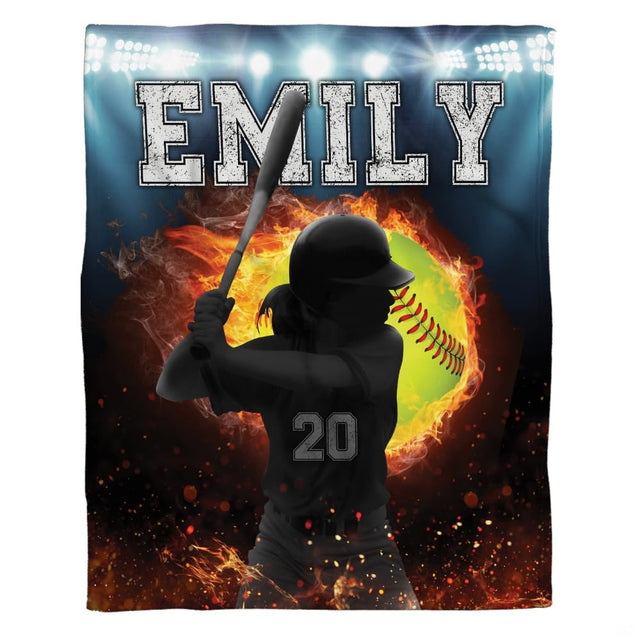Female softball batter swinging silhouette with flaming ball and floodlights against blue backdrop.