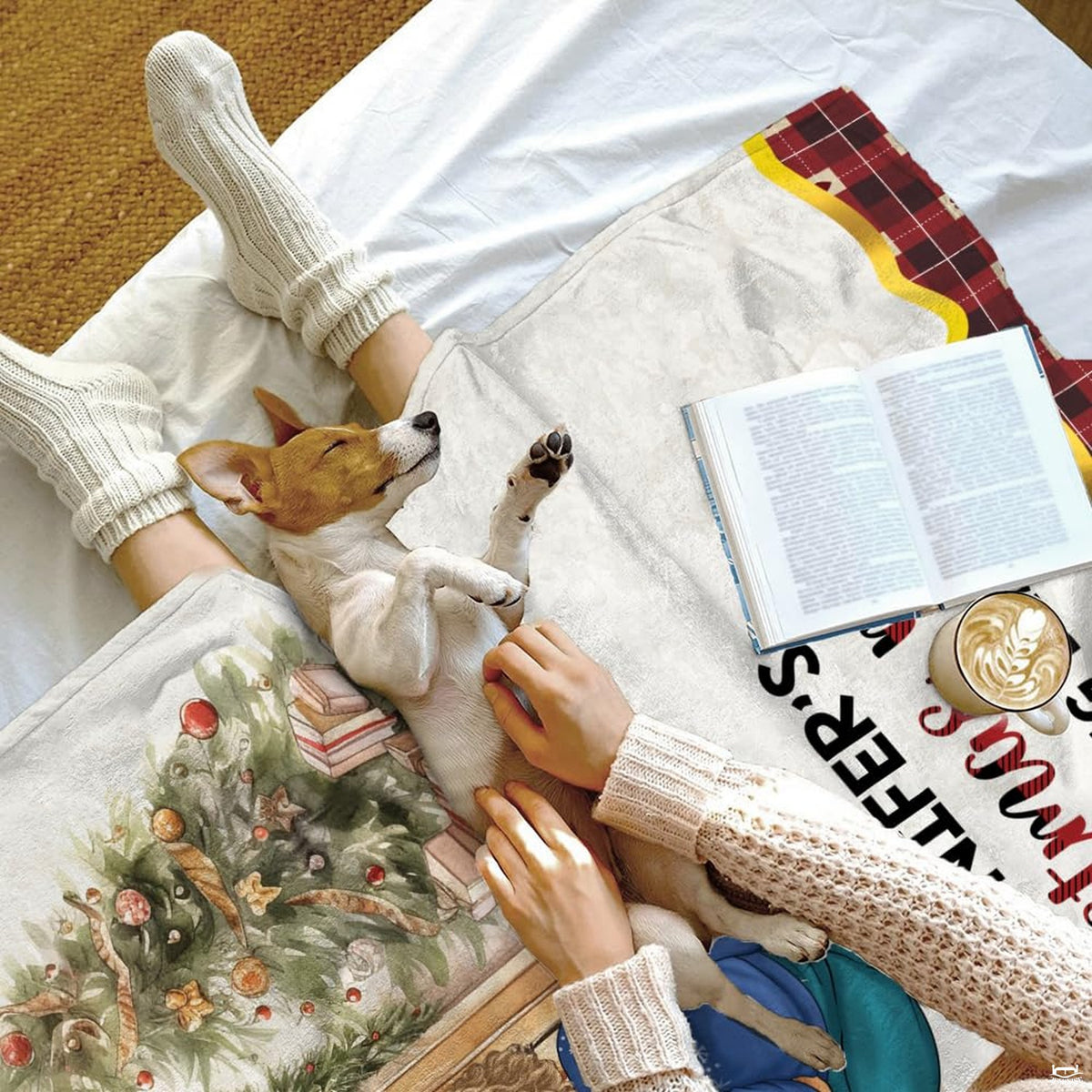 Cozy bed setting featuring puppy napping beside folded watercolor holiday parlor throw blanket.