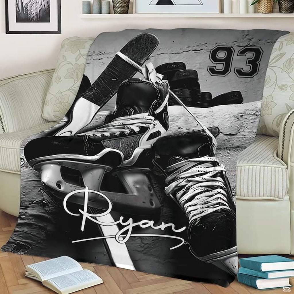 Ice hockey skates stick pucks sports blanket folded on lounge sofa