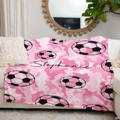 Person holding pink camo soccer pattern design blanket