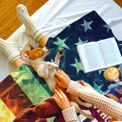 Top-down view of person relaxing under patriotic football blanket alongside small dog