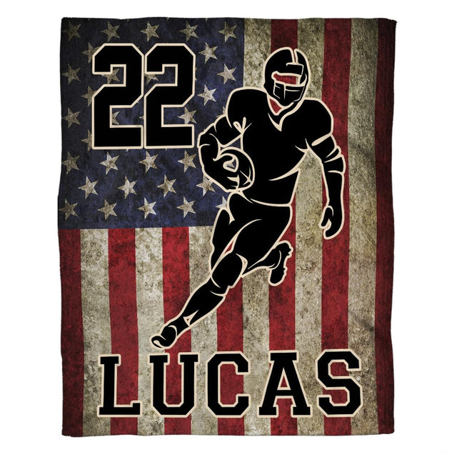 Woman holding open patriotic football throw blanket showing weathered stars and runner artwork