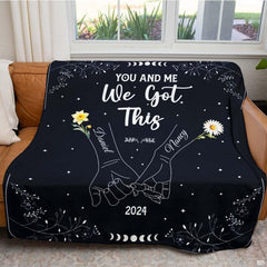 Folded throw blanket presentation highlighting white linework on deep black field.