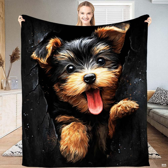Yorkshire Terrier puppy with tan and black fur peering out from a torn wall opening on stylish bedding.