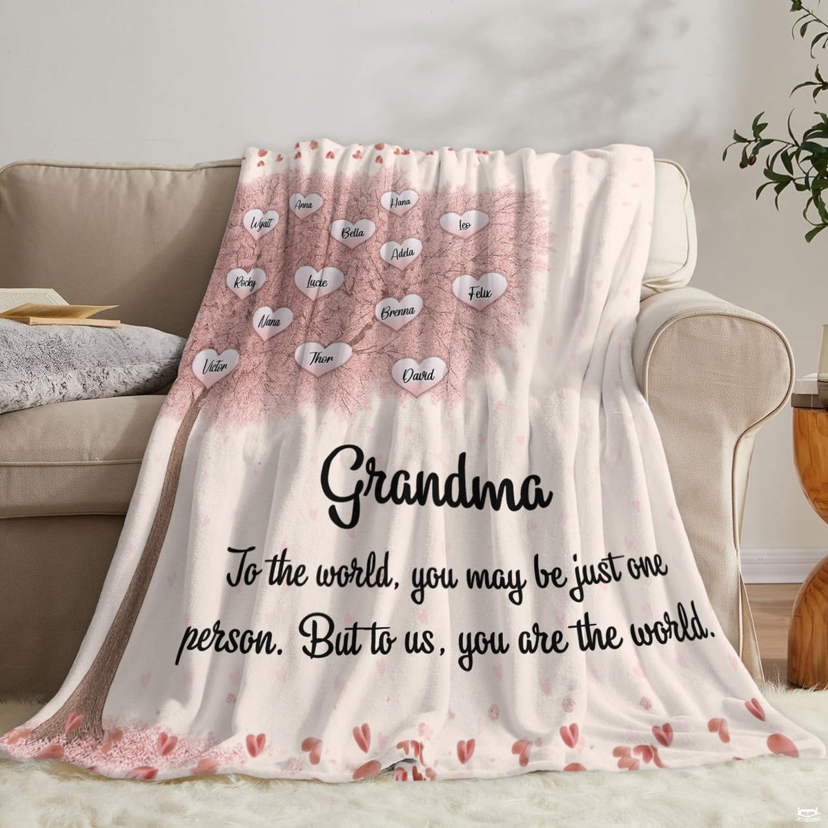 Pink cherry blossom blanket draped elegantly over beige living room armchair and couch