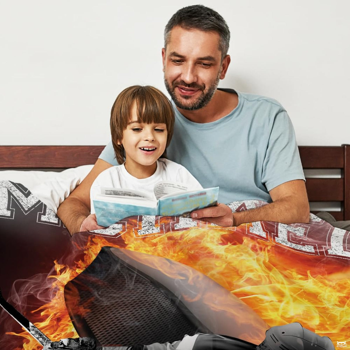 Bed mockup showing top section of flaming hockey artwork with father and son reading together.