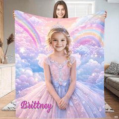 Model holding open a princess blanket featuring a girl in a tiara and gown surrounded by pastel rainbows.