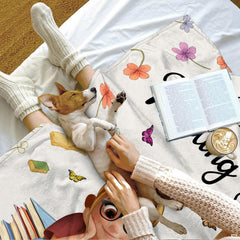 Bedroom interior showcasing the carnation reader girl throw blanket displayed over an accent lounge armchair.