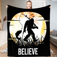 Fishing Bigfoot moon silhouette throw blanket featuring Sasquatch with fishing rod before glowing harvest moon