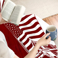 Detailed perspective of the waving American flag and heraldic Maltese cross badge on the throw blanket