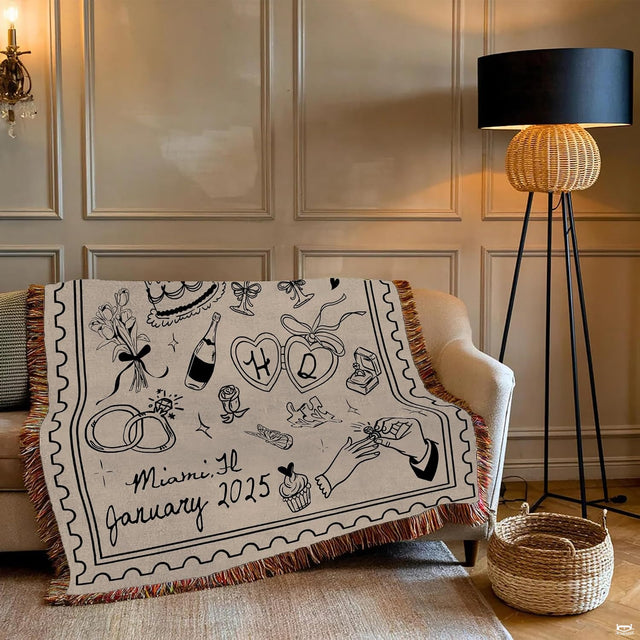 Close-up of wedding line art drawings including tiered cake, champagne glasses, and wedding rings on a blanket