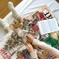 Cozy bed setting featuring puppy napping beside folded watercolor Christmas hearth throw blanket.