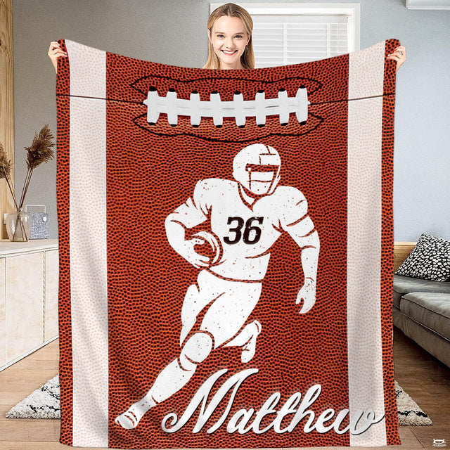 Football runner throw blanket held upright showcasing pebbled grain texture and side stripes.