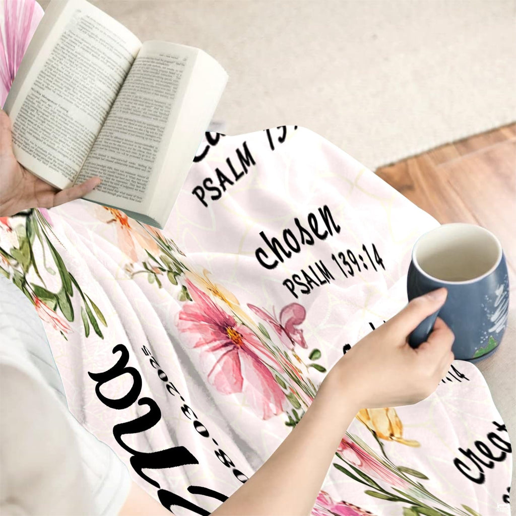 Faith-inspired floral cross artwork folded neatly across indoor seating beside an open book and coffee cup