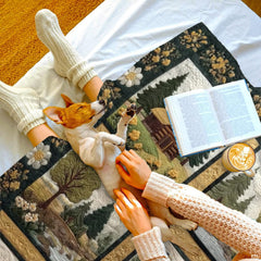 Close-up perspective of bear silhouette and log cabin panels on throw blanket