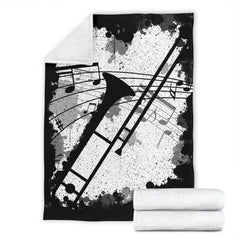 Trombone music graphic blanket spread across a bed in a modern room setting.