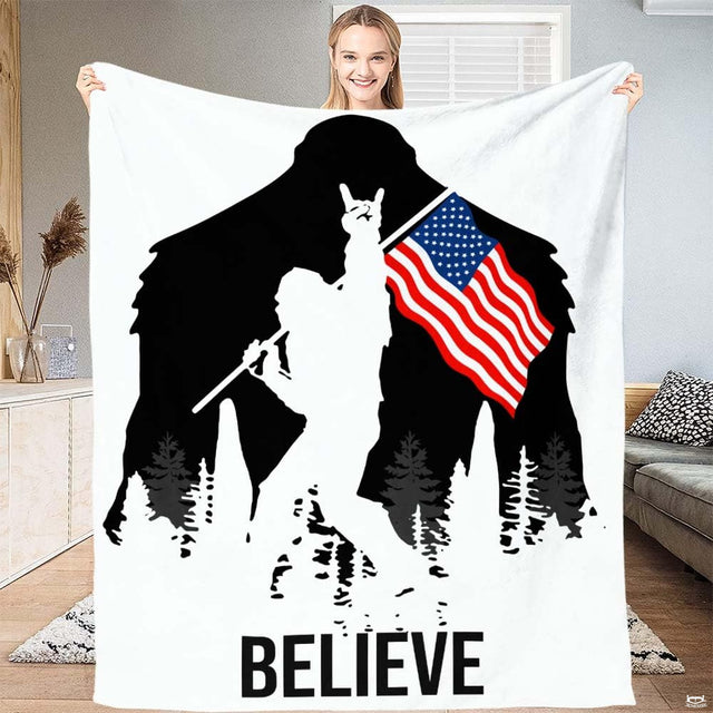 Bigfoot silhouette with rock hand sign, American flag, pine trees, and bold typography, view 1.