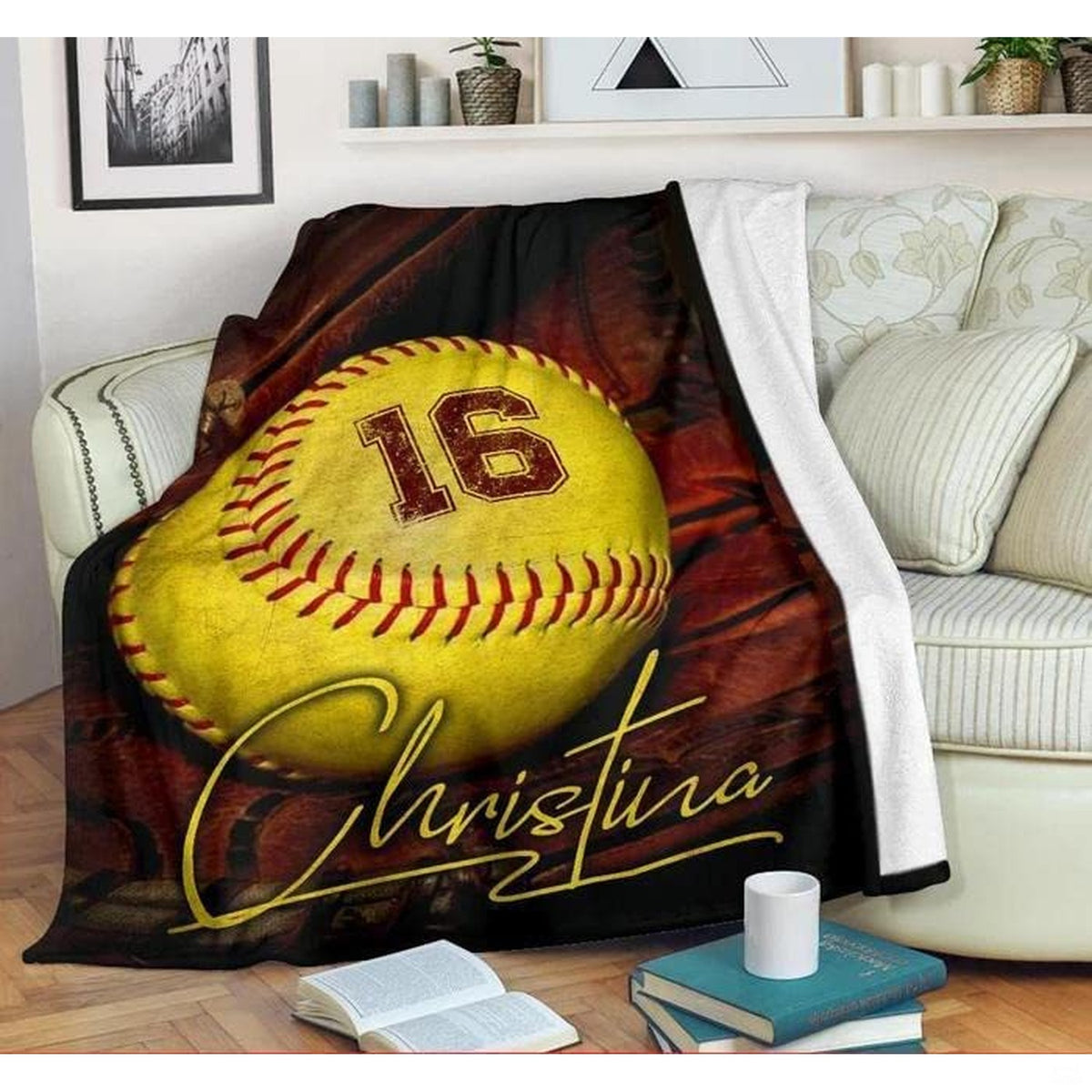 Sports graphic throw blanket arranged on an armchair beside books and a warm beverage.