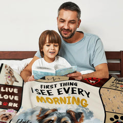 Adult and child seated together indoors with dog collage blanket.