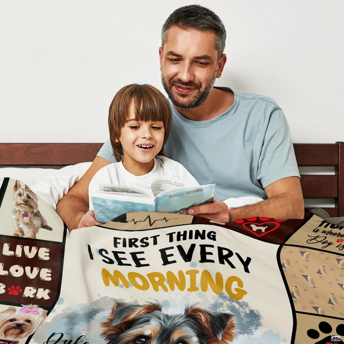 Adult and child seated together indoors with dog collage blanket.