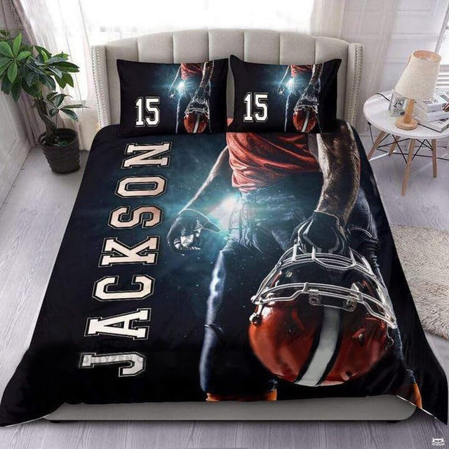 Silver and blush coral football sports bedding featuring textured football graphic and yard lines on a bed