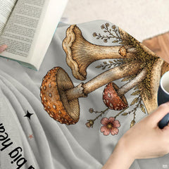 Whimsical forest mushroom and wildflower print displayed across vintage botanical bedding in a thematic accent room.