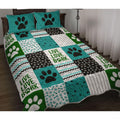 Teal animal bedding set displaying dog paw prints, bone patterns, and chevron patchwork across a bed setting.