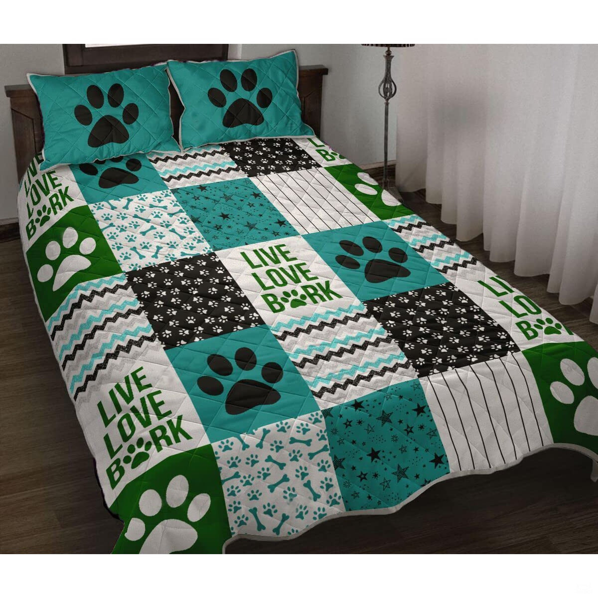 Teal animal bedding set displaying dog paw prints, bone patterns, and chevron patchwork across a bed setting.