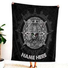 Woman standing indoors holding up dark Aztec warrior sun stone graphic textile.