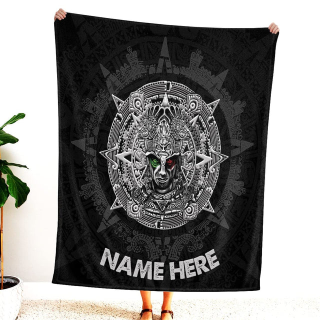 Woman standing indoors holding up dark Aztec warrior sun stone graphic textile.